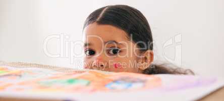 Someone made a mess and it wasnt me. Shot of an adorable little girl peeking over a table while busy doing art.