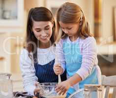 This is my favourite way to bond. Shot of a young woman helping her daughter stir a bowl of cake batter.