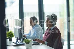 Dealing with the daily calls. Shot of call centre agents working in an office.