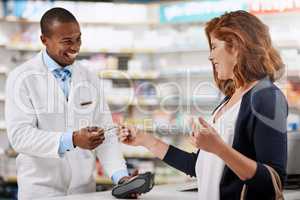 Sort all your medical bills with ease. Shot of a customer using a credit card to pay for a purchase in a pharmacy.