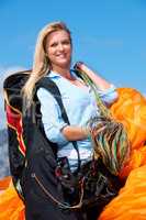 Its a great day to fly. Shot of a young woman getting ready to go paragliding.