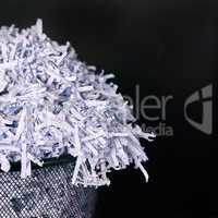 Leaving no paper trail. Studio shot of shredded paper in a dustbin against a black background.