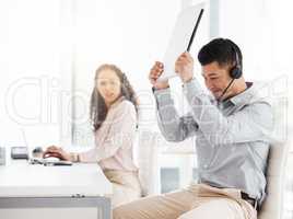 This darn thing wont work. Shot of a young call centre agent angrily smashing a laptop while working in an office.