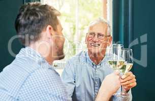 Heres to you and me dad. Shot of a cheerful elderly man and his son sharing a celebratory toast with wine glasses at home.