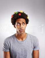 Its time to think in color. Shot of a young man with colorful paper in his hair against a gray background.