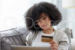 Shopping online really is that much more convenient. Shot of a young woman using a laptop and credit card at home.