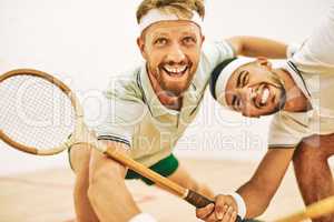 Hit the ball off the wall. Shot of two young men playing a game of squash.