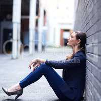 Its the quiet moments that keep her focused. Shot of an attractive businesswoman taking a break outside of her office.