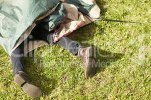 Camping disaster. Cropped view of a mans legs while trapped beneath a tent.