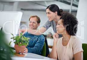 None of us is as smart as all of us. Shot of a group of creative businesspeople working together on a computer in the office.