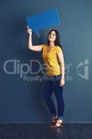 Empower your voice. Studio portrait of an attractive young woman holding a speech bubble against a blue background.