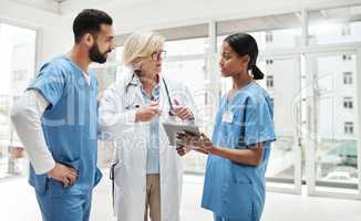 Quality healthcare is all about putting the patient at the centre. Shot of a group of medical practitioners having a discussion in a hospital.