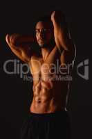 Confidence is a muscle, keep working on it. Studio shot of a fit young man posing against a black background.