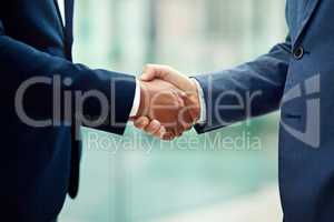 An introduction to business. Cropped shot of two unidentifiable businessmen shaking hands in the office.