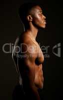 Every pound of muscle is pure man. Studio shot of a fit young man posing against a black background.