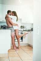 Turning up the heat in the kitchen. Shot of a loving young couple sharing an intimate moment in their kitchen at home.