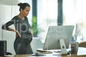 Tying together some loose ends before maternity leave. Shot of a pregnant businesswoman working in an office.
