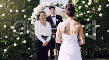 Shes a few steps away from her happiness. Rearview shot of an unrecognizable lesbian bride walking towards the altar on her wedding day.
