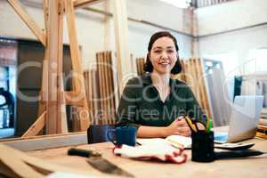 We trim wood into beautiful pieces for your home. Cropped shot of a female carpenter sitting at her desk in a workshop.