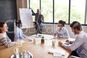 Getting them up to speed. Shot a mature businessman giving a presentation in the boardroom.