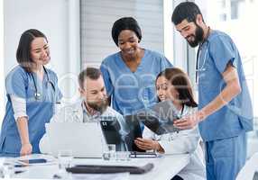 Coming together to do more thorough evaluations. Shot of a group of medical practitioners analysing x-rays in a hospital boardroom.