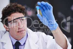 The future of medical science is in his hands. A scientist looking at a sample in a test tube.