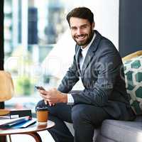 Success is my biggest craving. Portrait of a young businessman texting on a cellphone in a modern office.