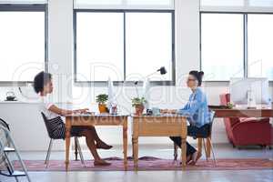 Creative space for contemporary business. Wide angle image of two female creative professionals in an open plan office space.