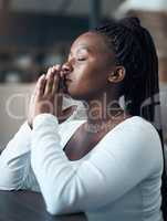I pray that things get better. Cropped shot of an attractive young woman kneeling alone and praying in her home.