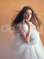 In a whimsical kind if mood. Shot of a beautiful young woman posing with a ballet skirt in studio.