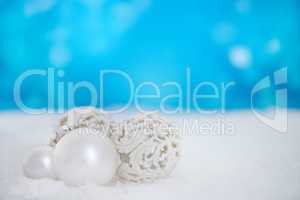 Wishing you a beautiful Christmas. Some christmas baubles lying on a bed of snow.