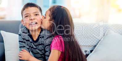 Yuck, girls are weird. Shot of an adorable little girl kissing her big brother on the cheek at home.