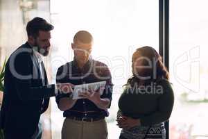 We can make a few changes here. Shot of a focused group of businesspeople having a discussion while using a digital laptop in a boardroom.