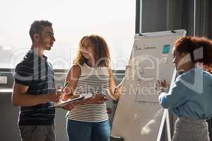 Investing the time to perfect their vision. Shot of a group of young designers brainstorming on a whiteboard in an office.