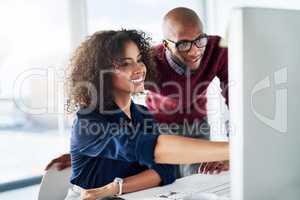 This one, right here. Cropped shot of a male supervisor helping an attractive young businesswoman while working in their office.