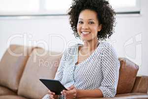 Leisurely day at home. Portrait of an attractive woman relaxing at home with a digital tablet.