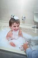 Turning bath time into playtime. Cropped shot of a little boy sitting in a bathtub.