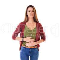 I dont feel too good. Studio shot of a young woman holding her stomach and feeling unwell isolated on white.