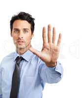 Stop right there. Studio shot of a young businessman showing a stop gesture.