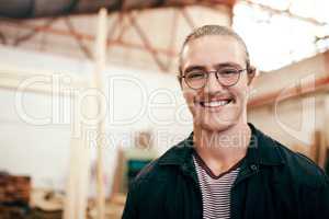 Im always ready to help you design your dream home. Portrait of a handsome young carpenter working inside his workshop.