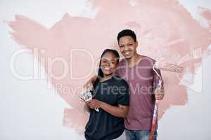 Art is the ultimate expression of love. Shot of a young couple painting a wall pink.