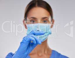 This is for your own protection. Shot of a young female nurse holding a needle against a studio background.