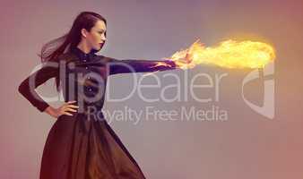Lighting it up. Conceptual shot of a young female martial artist releasing a fireball.