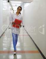 Beauty and brains. Portrait of an attractive young doctor walking down a passage in a medical center.