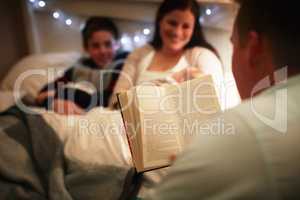 Theyre a family who share a love of reading. Cropped shot of a father reading a bedtime story to his wife and son.