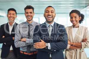 The experts have arrived. Portrait of a group of cheerful young businesspeople standing with their arms folded in the office during the day.
