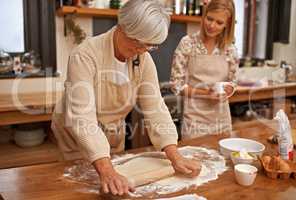 Learning grandmas secret recipes. A grandmother teaching her granddaughter how to bake.