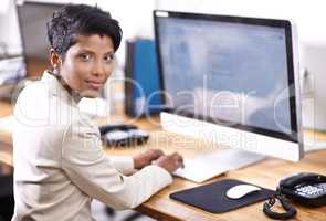 Shes a very diligent worker. Portrait of an attractive businesswoman working on a desktop computer.