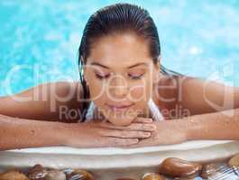 Remember to pamper yourself. Shot of a young woman relaxing at a spa pool.