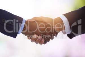 Coin and cash for poise and panache. Shot of two unrecognizable businessmen shaking hands against a blurry background.